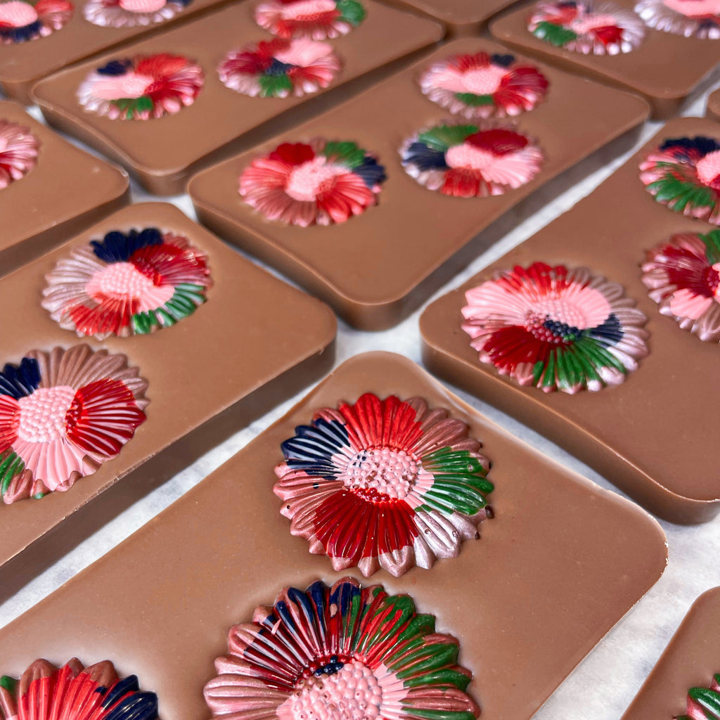 Milk chocolate bars decorated with hand-painted multicoloured chocolate flowers 