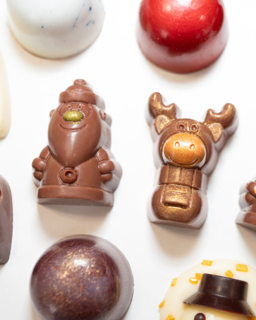 Closeup of La Chocolatrice festive chocolates featuring a Santa, reindeer, and various luxury chocolate shapes with holiday-themed decorations.