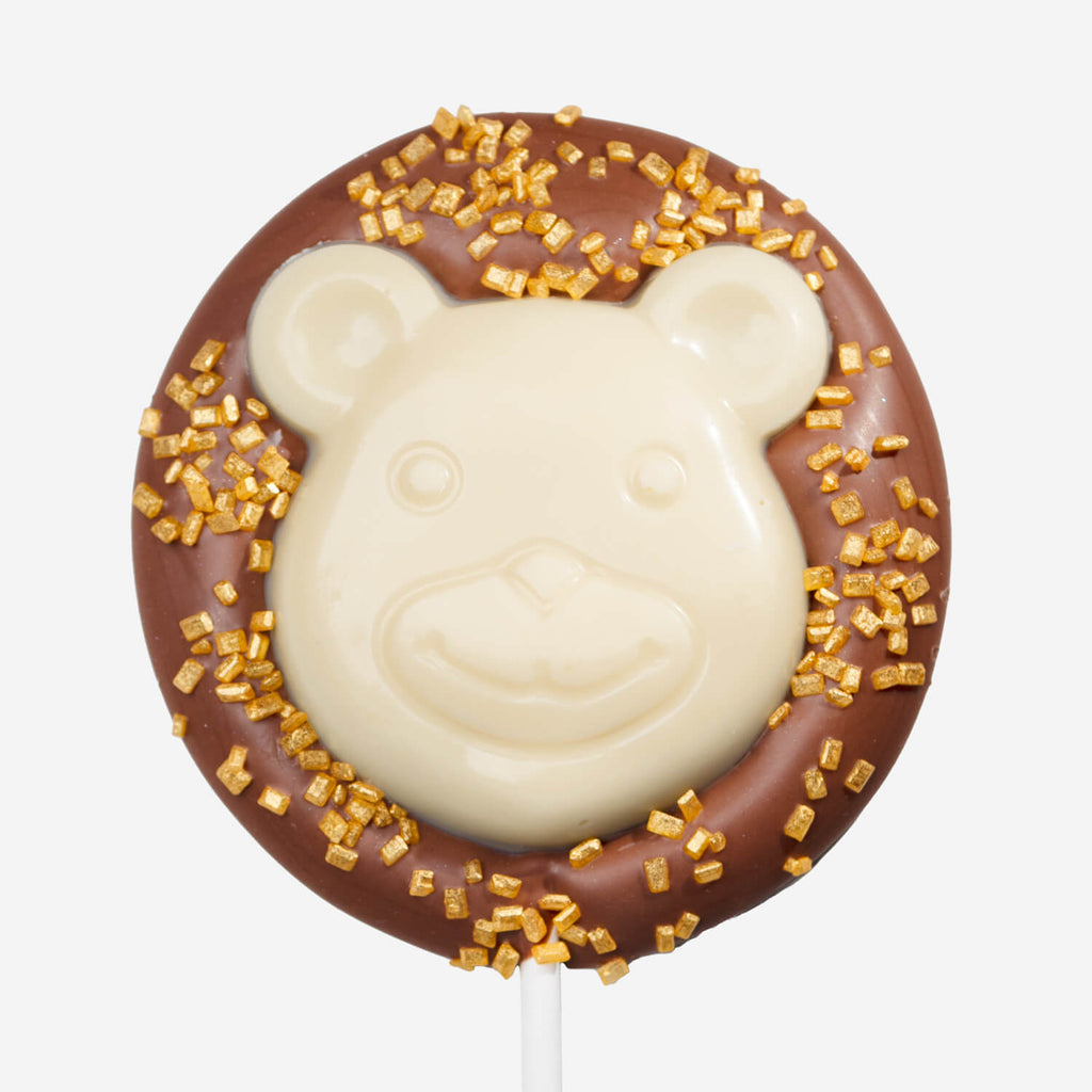 Chocolate bear lollipop with white and milk chocolate, sprinkled with gold decorations by La Chocolatrice.