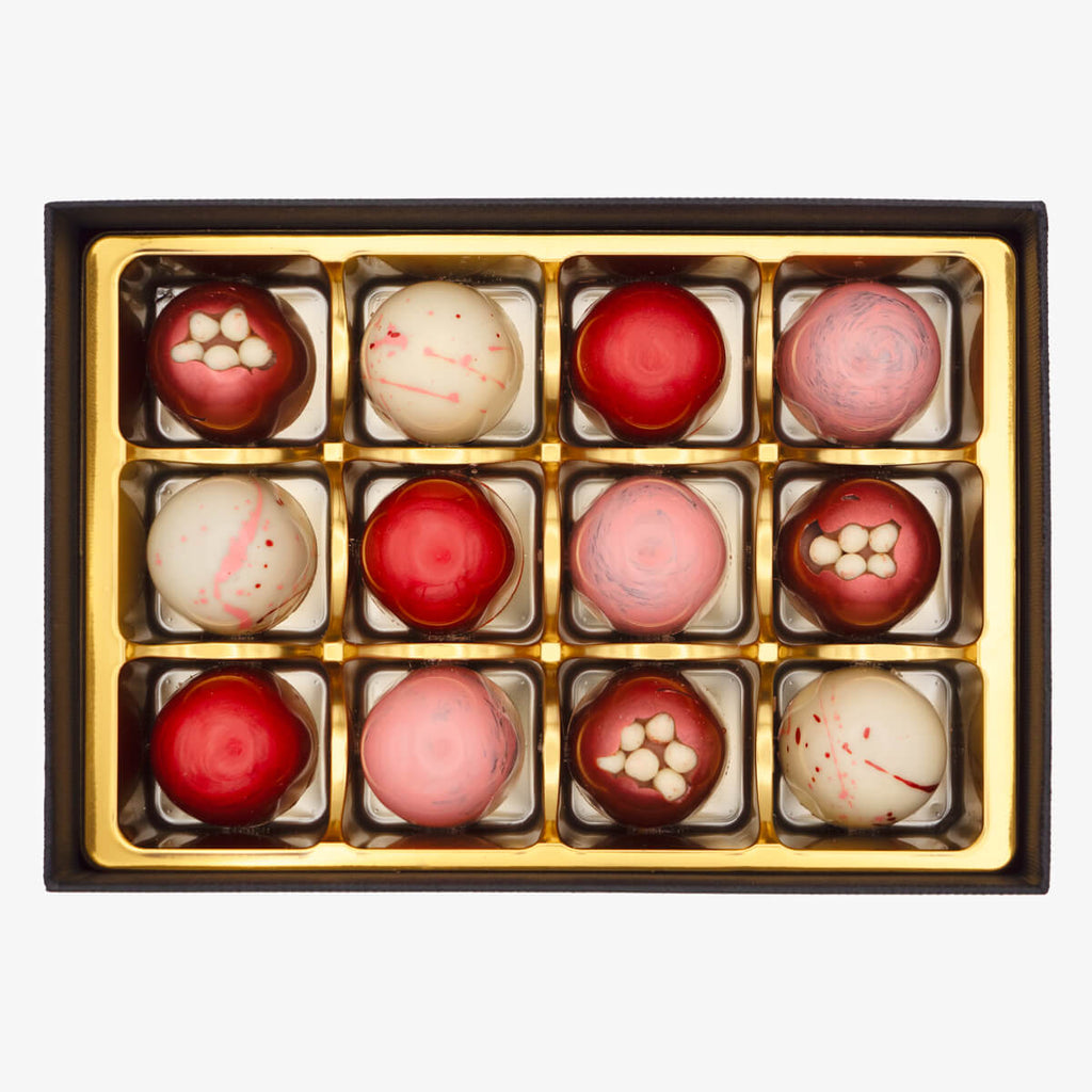 Medium box of La Choc bonbons with a mix of red, pink, and white chocolates in decorative packaging.